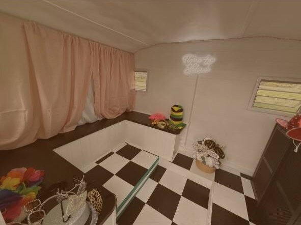 Vintage camper photo booth interior with props, seating and checkered floor